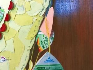 Detalhes do coração amarelo, sendo visíveis pequenos corações da embalagem Compal e o respetivo selo da Tetra Pak.